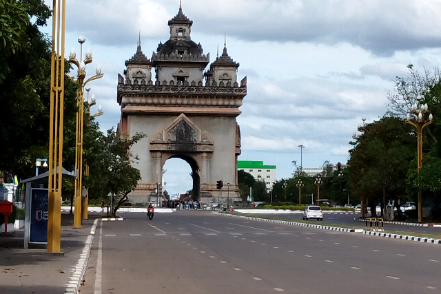 Title:『 なぜパトゥーサイは大通りに建てられたのか』画像説明 :*なぜパトゥーサイは大通りに建てられたのか*パトゥーサイが建てられた場所はビエンチャン市内でも交通量の多い大通りの中央で、*周囲に遺跡や寺院が並んでいるわけではなく、街の景色の中に突然現れるため、違和感を覚える人も少なくないのでは?