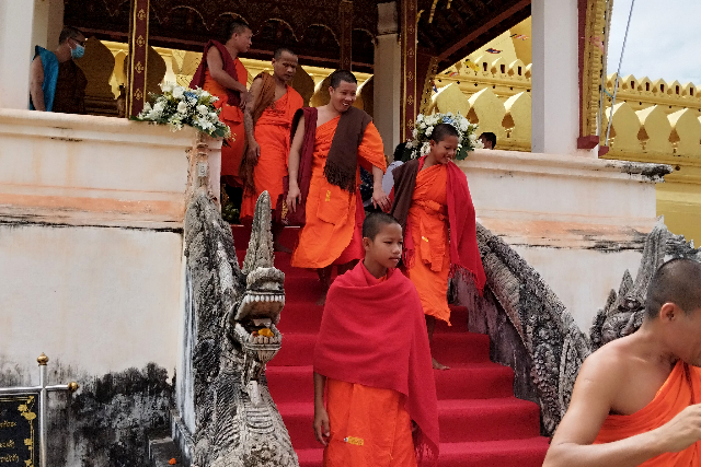 Title:『 儀式を終え、本堂から出てくる沙弥（子どもの僧侶）たち』画像説明 :*儀式を終え、本堂から出てくる沙弥（子どもの僧侶）たち*タートルアン祭りの期間中、仏塔の一段高い場所にある本堂では、読経や寄進に関する仏教儀式が行われています*ラオスでは、子どものうちに一定期間出家し、仏教を学びながら功徳を積む文化が根付いているそうです*この写真は、儀式を終え 本堂から次々と出てくる<strong><noscript><img decoding=