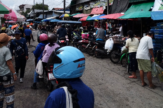 Title:『 仕入れに来る人たちの様子』画像説明 :*仕入れに来る人たちの様子*ムアンマイ市場を歩いていると観光客はほとんど見かけず、仕入れに来ている人たちばかりだ*細い路地の両側に店が並び、その間を人やバイクがひっきりなしに行き交う*写真に写っている光景こそが、この市場の日常だ